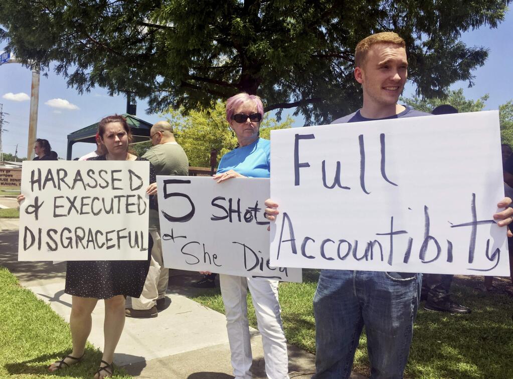 From left, Felicia Young, 28, Susan Cummings, 61, and Bryon Cummings, 22, demonstrate outside Baytown Police Department in Baytown, Texas, Tuesday, May 14, 2019. A Texas police officer fatally shot a woman who police said grabbed his Taser and used it against him, moments after she seemed to say 'I'm pregnant' in an altercation captured on video. (AP Photo/John L. Mone)