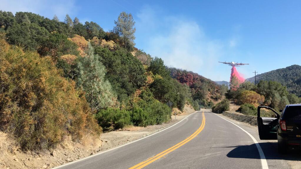 A Cal Fire air tanker drops fire retardant on the Canyon fire near Lake Berryessa on Monday, July 22, 2019. (KENT PORTER/Press Democrat)