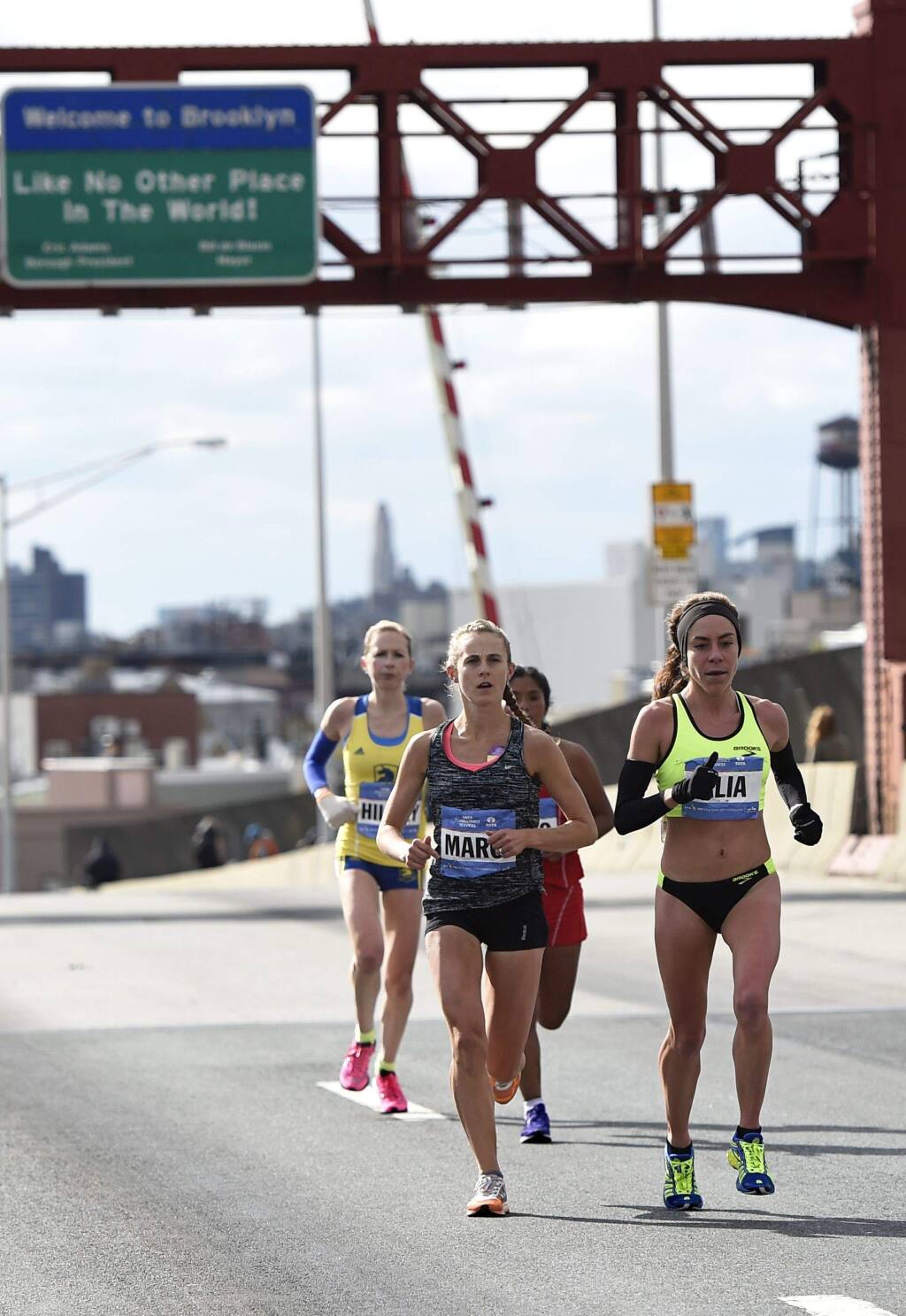 Hilary Dionne of the Untied States, left, Marci Gage of the United States, center, and Alia Gray of the Untied States cross the Pulaski Bridge to enter the Queens borough of New York during the New York City Marathon on Sunday, Nov. 2, 2014, in New York. Dionne finished 18th, Gage finished 17th and Gray finished 16th overall for women. (AP Photo/Kathy Kmonicek)