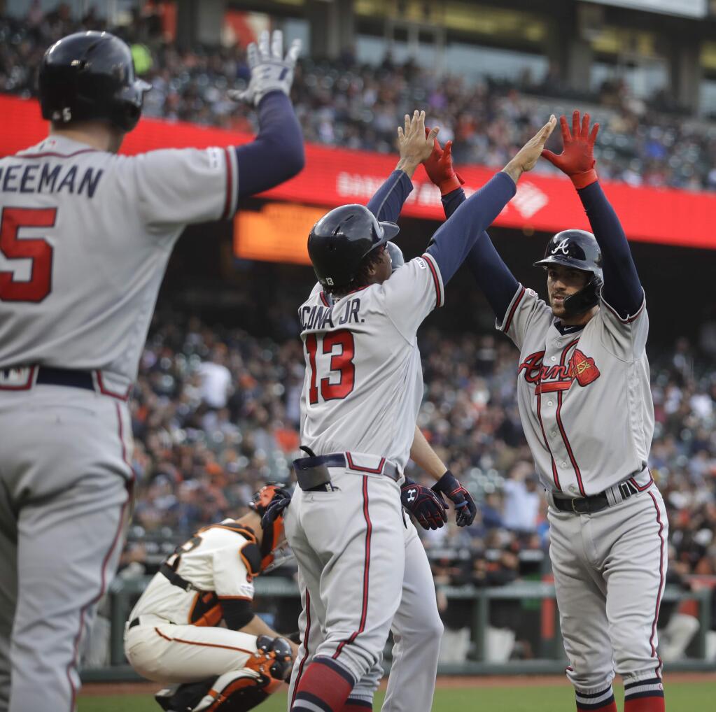 The Atlanta Braves' Dansby Swanson, right, celebrates with Ronald Acuna Jr. (13) and Freddie Freeman (5) after hitting a three-run home run off the San Francisco Giants' Jeff Samardzija during the second inning, Wednesday, May 22, 2019, in San Francisco. (AP Photo/Ben Margot)