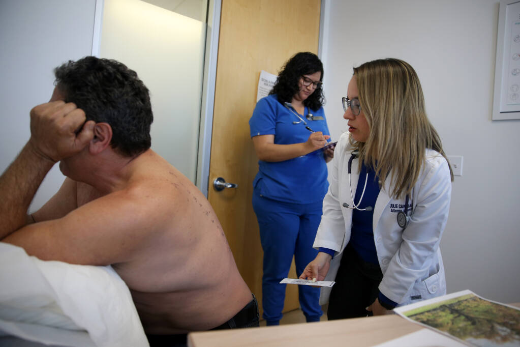 Allergist Dr. Julie Caraballo measures patient Jim Rask's reaction to allergens following a skin prick test while RN Ana Savelberg records the data at FamilyCare Allergy & Asthma in Petaluma, Tuesday, April 18, 2023. (Beth Schlanker / The Press Democrat)