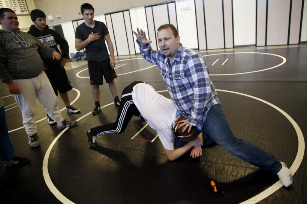 Petaluma wrestling coach Paul Schloesser demonstrates technique during practice on Wednesday, Dec. 16, 2015 in Petaluma. (BETH SCHLANKER / The Press Democrat)