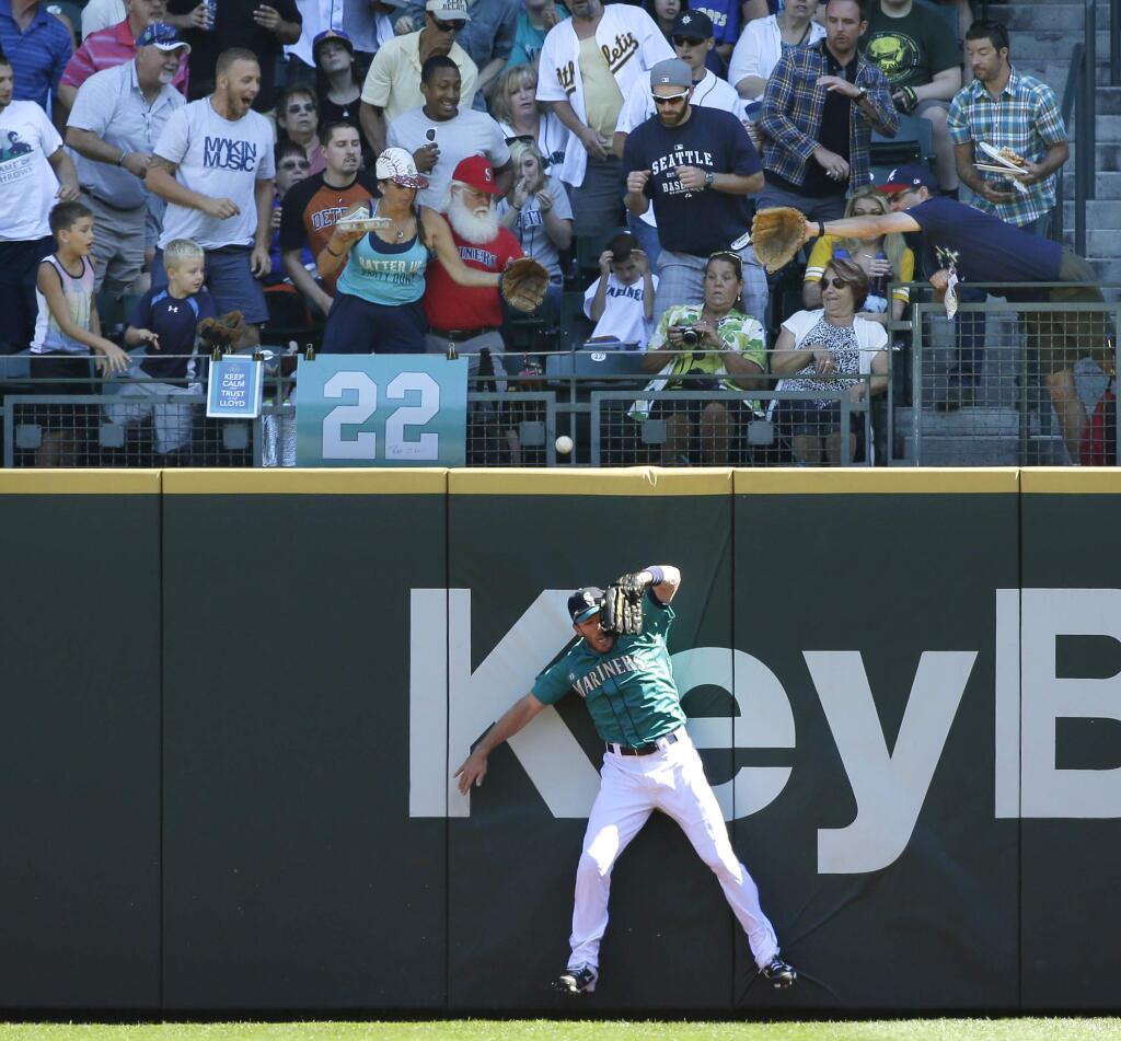 Seattle Mariners outfielder Chris Denorfia crashes into the wall trying to catch a solo home run hit by Oakland Athletics' Sam Fuld in the first inning of a baseball game, Sunday, Sept. 14, 2014, in Seattle. (AP Photo/Ted S. Warren)