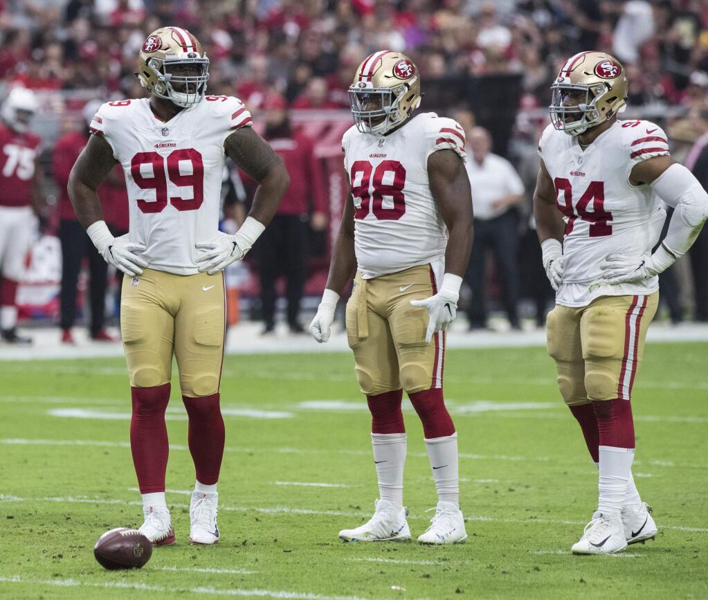 In this Oct. 28, 2018, file photo, the San Francisco 49ers' DeForest Buckner (99), Ronald Blair III (98) and Solomon Thomas (94) wait for a play against the Arizona Cardinals in Glendale, Ariz. (AP Photo/Darryl Webb, File)