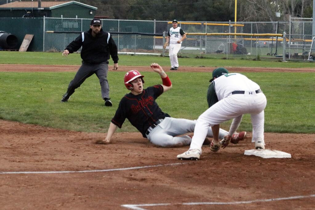 San Rafael's Daren O'Hagan can't avoid Dusty Pierece's tag as he slides into third during action at Arnold Field on Tuesday, March 19. The Dragons went on to win, 9-4 and remain undefeated. (Christian Kallen / Index-Tribune)
