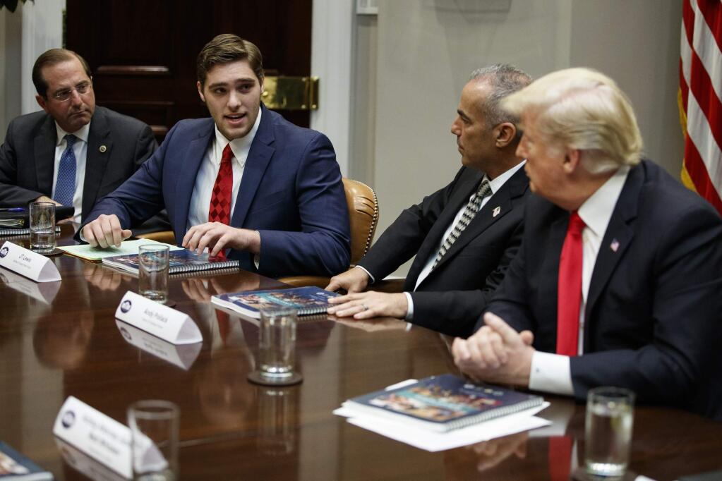 FILE - In this Dec. 18, 2018 file photo, JT Lewis, brother of Sandy Hook victim Jesse Lewis, speaks to President Donald Trump during a roundtable discussion on the Federal Commission on School Safety report, in the Roosevelt Room of the White House in Washington. From left, Secretary of Health and Human Services Alex Azar, Lewis, Andy Pollack, father of Parkland victim Meadow Pollack, and Trump. Lewis lost his 6-year-old brother, Jesse, in the 2012 Sandy Hook Elementary School shooting. He now is a University of Connecticut student and is running for the 2020 state Senate as a Republican, calling for better school security and mental health programs. (AP Photo/Evan Vucci, File)