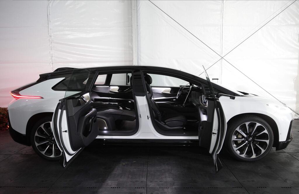 The Faraday Future FF 91, a long, low, and luxurious four-door EV is shown during the 'Faraday's Future: Transforming The Road of Future Mobility,' panel discussion at the AutoMobility LA auto show at the Los Angeles Convention Center in Los Angeles Tuesday, Nov. 19, 2019. (AP Photo/Damian Dovarganes)