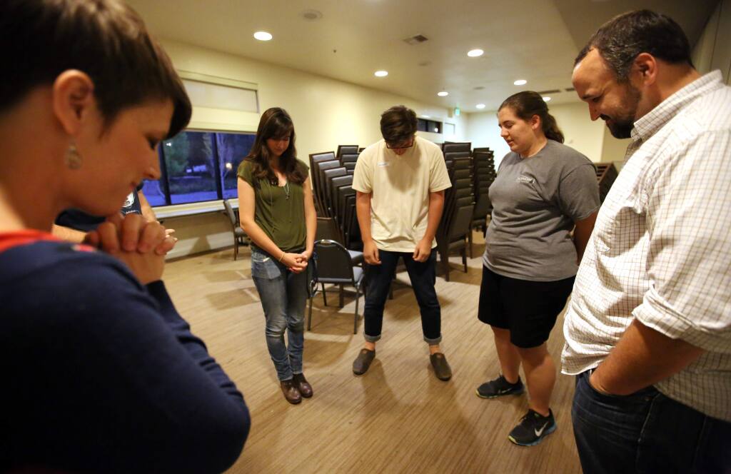 A small group including from left to right, Jenny Klouse, Chelsea Ruthrauff, Michael Palese, Jenna Lehman and Mark Pritchard, say a prayer prior to the start of the InterVarsity prayer session held at Sonoma State University, Thursday, September 18, 2014. (Crista Jeremiason / The Press Democrat)