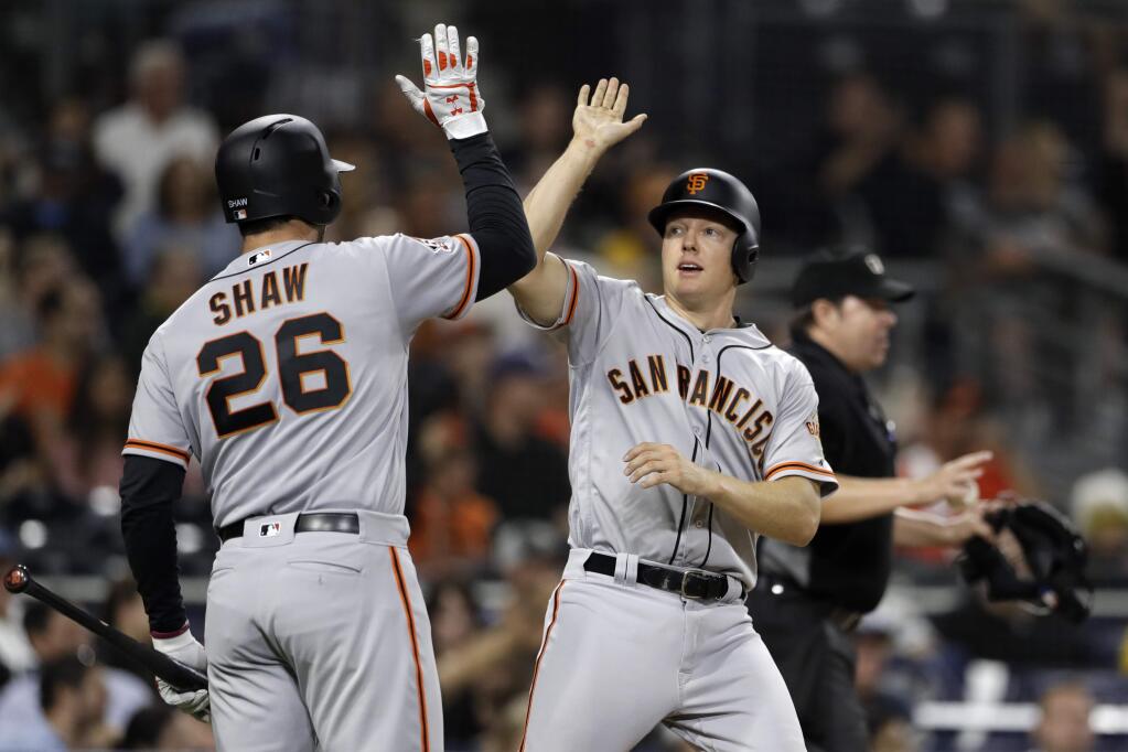 The San Francisco Giants' Nick Hundley, right, reacts with teammate Chris Shaw after scoring on a double by Hunter Pence during the fourth inning against the San Diego Padres on Tuesday, Sept. 18, 2018, in San Diego. (AP Photo/Gregory Bull)