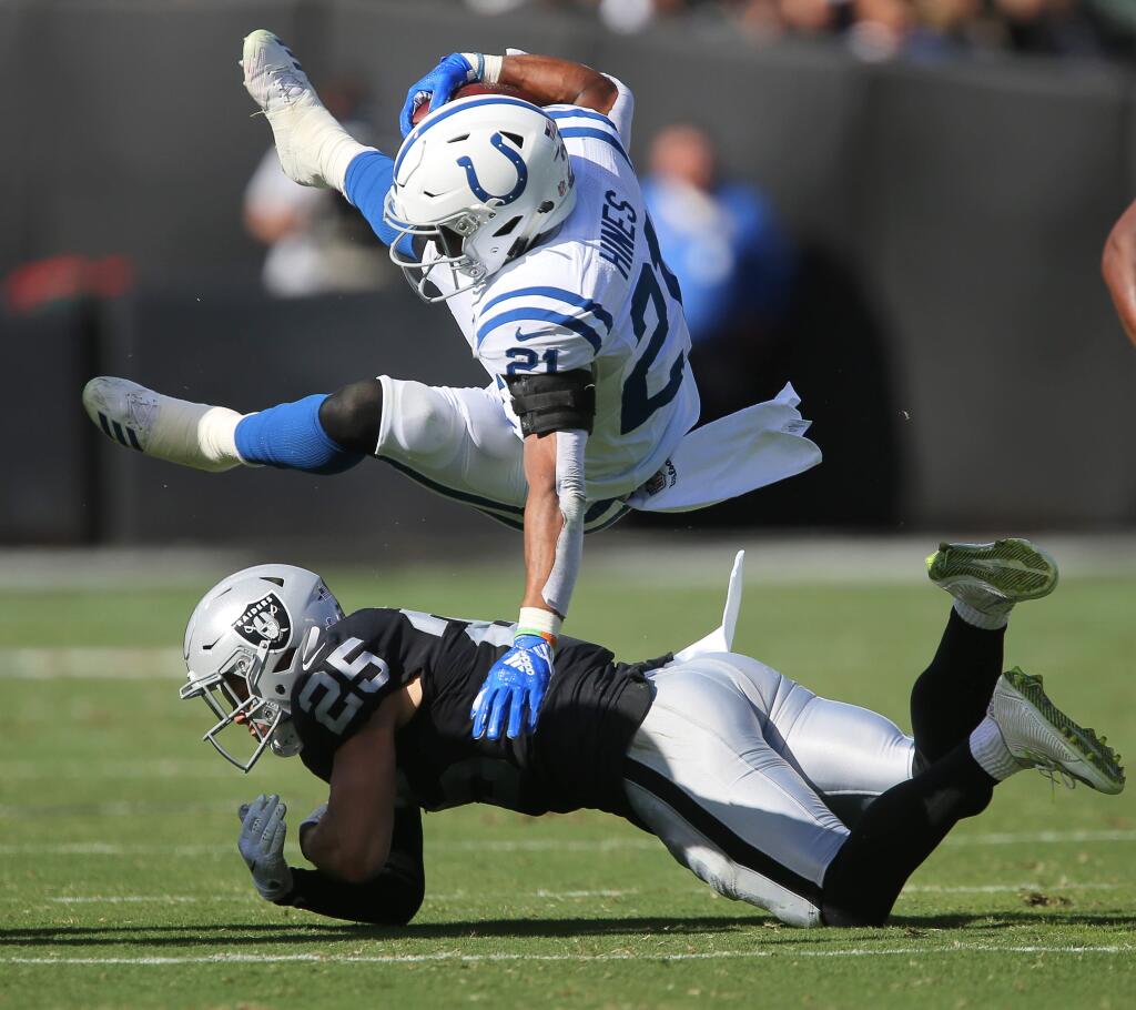 Indianapolis Colts running back Nyheim Hines is swept off his feet while trying to avoid a hit by Oakland Raiders safety Erik Harris, during their game in Oakland on Sunday, October 28, 2018. The Colts defeated the Raiders 42-28.(Christopher Chung/ The Press Democrat)
