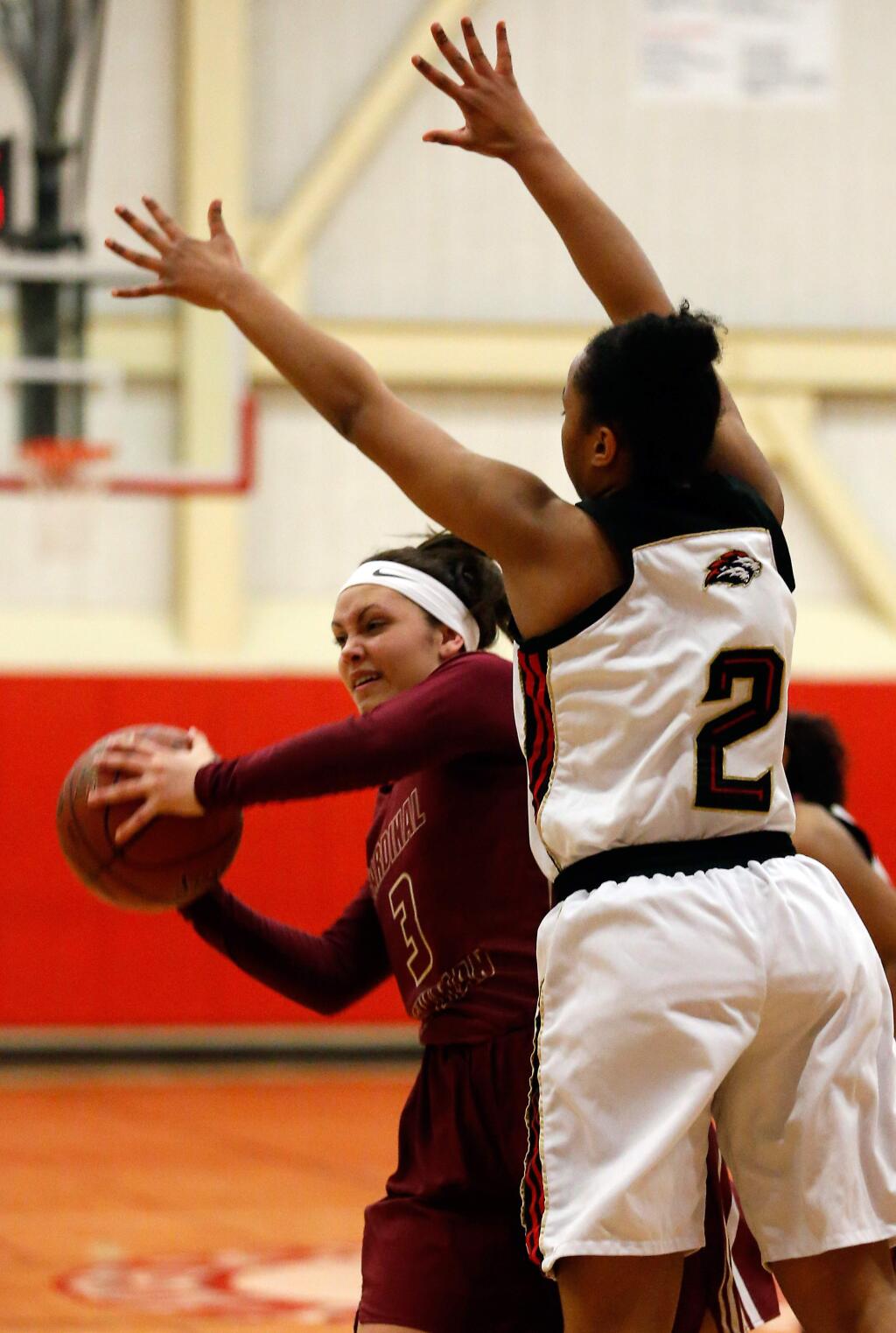 Cardinal Newman's Maiya Flores (3) is pressured to pass the ball by Salesian's Taimane Lesa-Hardee (2) during the first half of the NCS Division 4 championship girls basketball game between Cardinal Newman and Salesian Prep high schools in Albany, California, on Saturday, March 5, 2016. (Alvin Jornada / The Press Democrat)