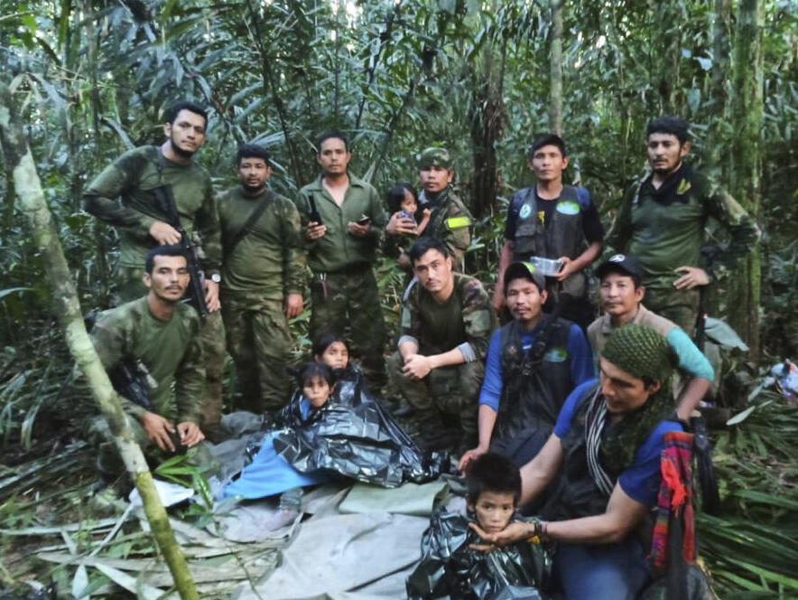 In this photo released by Colombia's Armed Forces Press Office, soldiers and Indigenous men pose for a photo with the four Indigenous brothers who were missing after a deadly plane crash, in the Solano jungle, Caqueta state, Colombia, Friday, June 9, 2023. Colombian President Gustavo Petro said Friday that authorities found alive the four children who survived a small plane crash 40 days ago and had been the subject of an intense search in the Amazon jungle. (Colombia's Armed Force Press Office via AP)