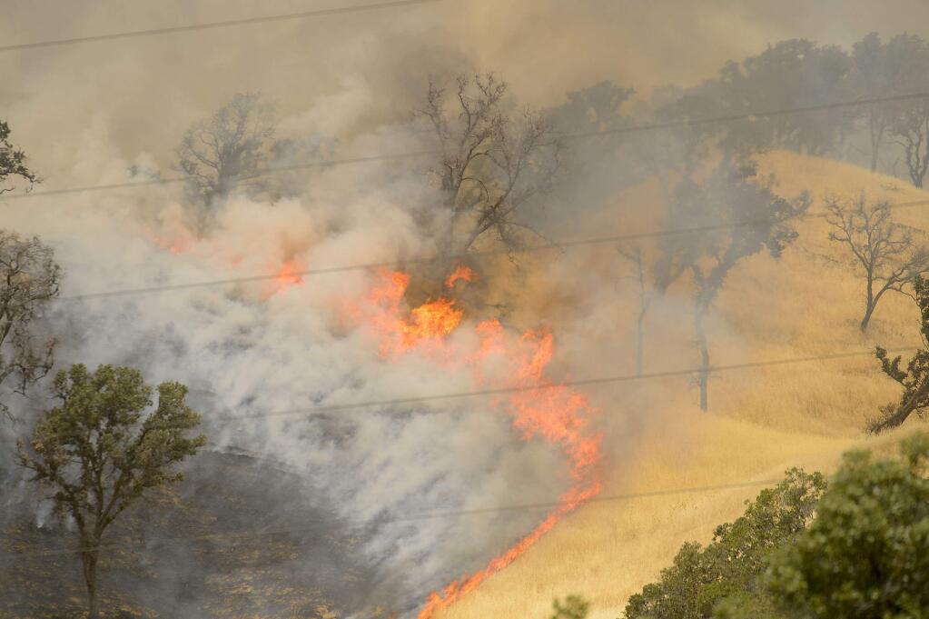 Fire burns the hillsides as the County fire continues near Lake Berryessa in Yolo County, California, on Tuesday, July 3, 2018. (Randall Benton/The Sacramento Bee via AP)