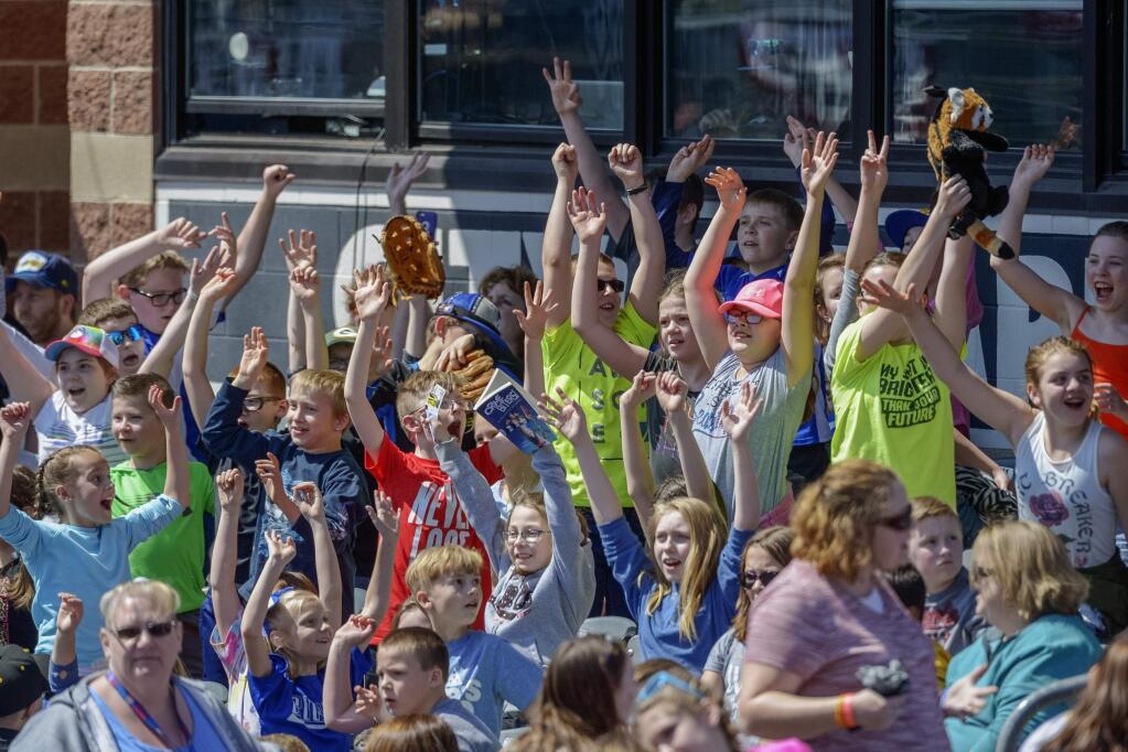 In this April 11, 2018, file photo, schoolchildren cheer as the West Virginia Power face the Lakewood BlueClaws at Appalachian Power Park, in Charleston, W.V. Some towns who have found their minor league teams on a possible Major League Baseball list of 42 teams to eliminate have begun fighting back. (Craig Hudson/Charleston Gazette-Mail via AP, File)