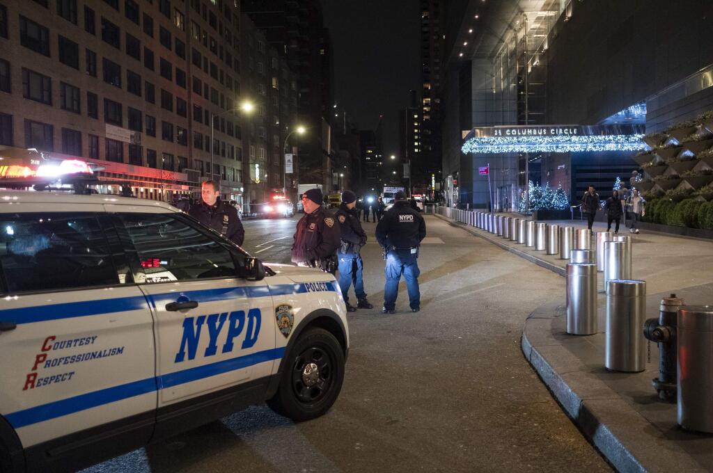 New York City police officers stand by near the Time Warner Center in New York Thursday, Dec. 6, 2018, after a bomb threat was called into the building and occupants were evacuated, including CNN employees. Police units swept the building with the NYPD bomb squad on standby. (AP Photo/Craig Ruttle)