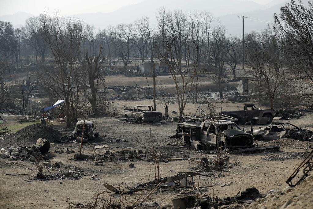 FILE - In this Aug. 11, 2018 file photo, burned out cars sit in a neighborhood burned in the Carr fire in Redding, Calif. (AP Photo/John Locher, File)