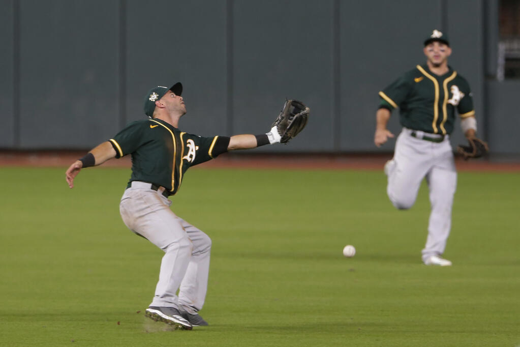 Oakland Athletics second baseman Tommy LaStella, left, misses the catch as center fielder Ramon Laureano, right, watches on the hit by Houston Astros’ Carlos Correa during the fifth inning of the second baseball game of a doubleheader Saturday, Aug. 29, 2020, in Houston. (AP Photo/Michael Wyke)