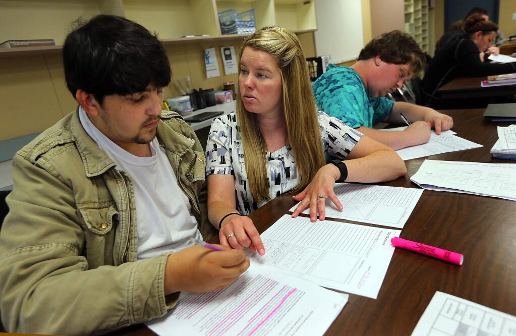 Teacher Heather Tait, center, works with Alex Robledo, 18, left and Mathew Stauer, 20 in the Youth Connections class at the Healdsburg Community Center. The program helps at-risk students make up class credits and earn their high school diplomas. (JOHN BURGESS / The Press Democrat)