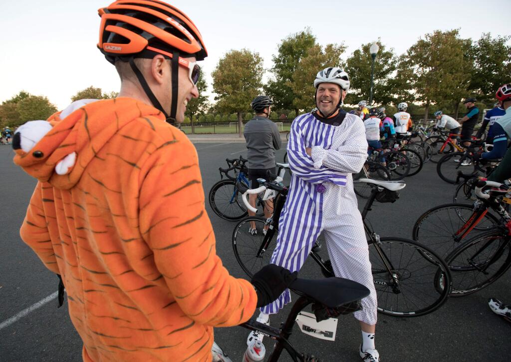 Ryan Kretzer, left, and Paul Reimer, both of Tucson, Arizona, wearing colorful outfits, talk before the start of Levi's GranFondo cycling race, at A Place to Play in Santa Rosa, Calif., on Saturday, October 5, 2019. (Photo by Darryl Bush / For The Press Democrat)