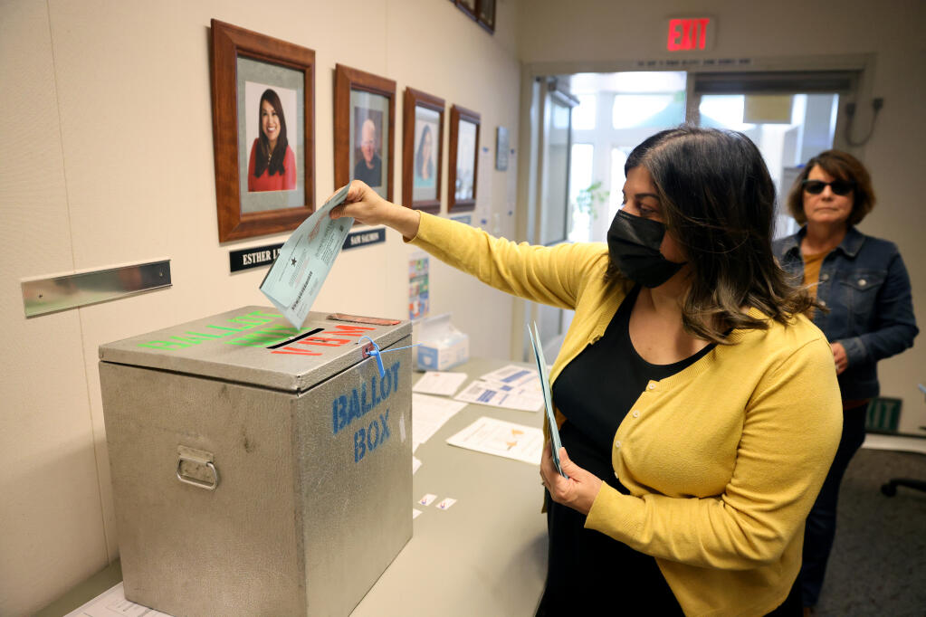Lanette Zootis places ballots for several people in the ballot box at the Windsor Civic Center in Windsor, on Tuesday, April 12, 2022. (Beth Schlanker / The Press Democrat)
