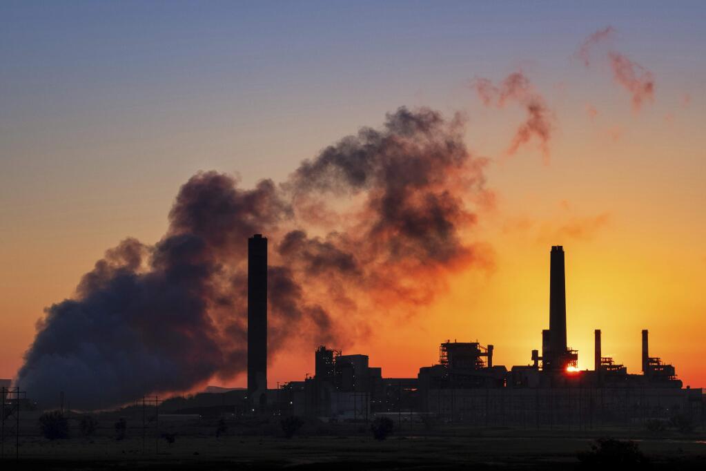 In this July 27, 2018 photo, the Dave Johnson coal-fired power plant is silhouetted against the morning sun in Glenrock, Wyo. The Trump administration on Tuesday proposed a major rollback of Obama-era regulations on coal-fired power plants, striking at one of the former administration's legacy programs to rein in climate-changing fossil-fuel emissions. (AP Photo/J. David Ake)