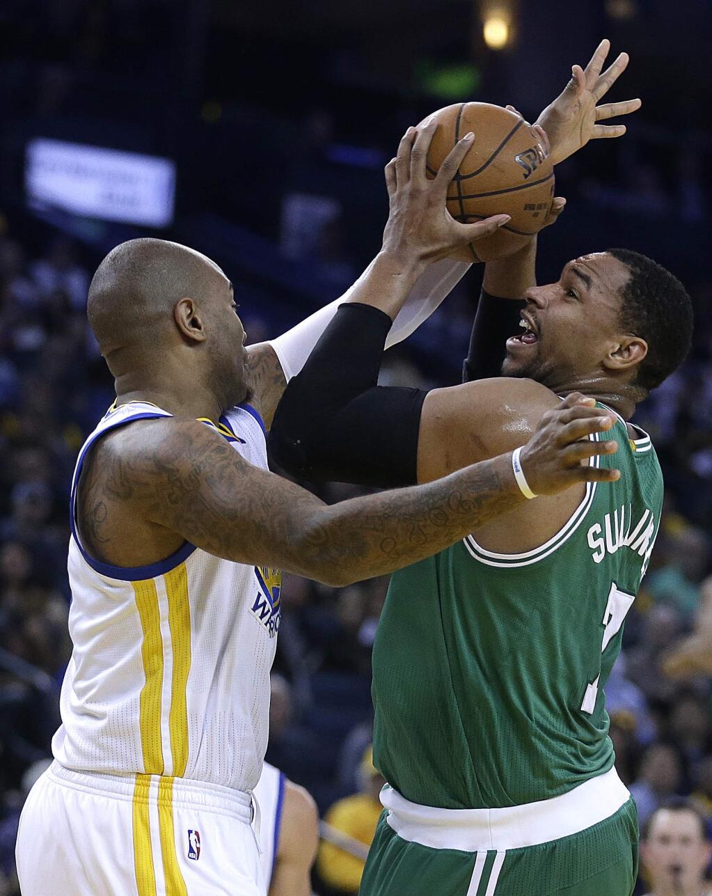 Boston Celtics' Jared Sullinger, right, looks to shoot against Golden State Warriors' Marreese Speights during the first half of an NBA basketball game, Sunday, Jan. 25, 2015, in Oakland, Calif. (AP Photo/Ben Margot)