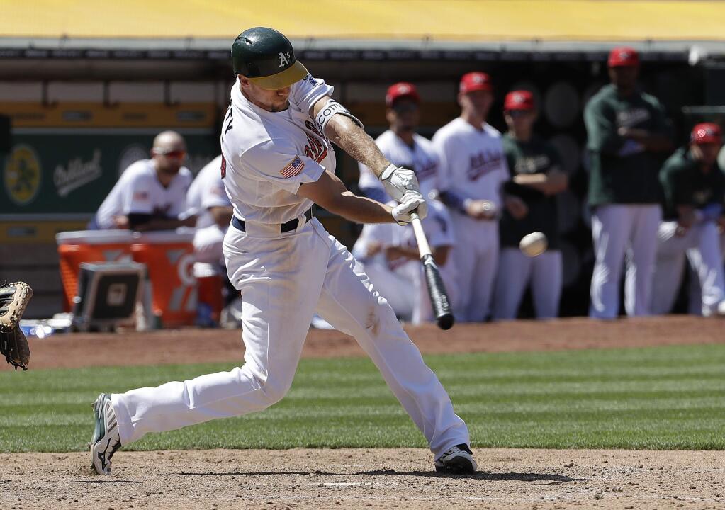 The Oakland Athletics' Stephen Piscotty hits a two-run double against the San Diego Padres during the eighth inning in Oakland, Wednesday, July 4, 2018. (AP Photo/Jeff Chiu)