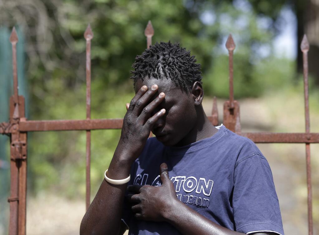 Baboucar Lowe, a 17-year-old migrant from Gambia touches his head during an interview with the Associated Press, in Nicolosi, Sicily, southern Italy, Wednesday, May 6, 2015. Baboucar nearly lost his life when the dinghy he was on deflated within sight of a rescue ship. He recounted the moment when more than 100 people aboard the deflating dinghy tried to climb aboard lines thrown by the Maltese freighter Zeran and dozens fell into the sea, drowning. (AP Photo/Antonio Calanni)