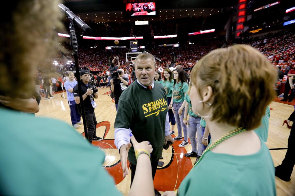 Houston Rockets owner Tilman Fertitta greets members on the Santa Fe High School choir who sang the national anthem before Game 5 of the NBA basketball playoffs Western Conference finals between the Houston Rockets and the Golden State Warriors, Thursday, May 24, 2018, in Houston. Ten people were killed in shootings at the school last week. (AP Photo/David J. Phillip)