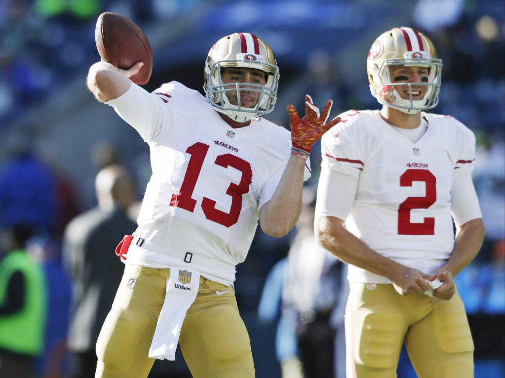 In this Nov. 22, 2015 photo, San Francisco 49ers quarterbacks Dylan Thompson, left and Blaine Gabbert warm up before an NFL football game against the Seattle Seahawks in Seattle. Thompson has spent the majority of his rookie season as the scout team quarterback, posing as Aaron Rodgers, Carson Palmer or Russell Wilson in practice to prepare the starting defense. Until this week. Now, his job is changing. In one whirlwind weekend, Thompson went from practice squad to active roster and backup to San Francisco starter Blaine Gabbert. (AP Photo/John Froschauer)