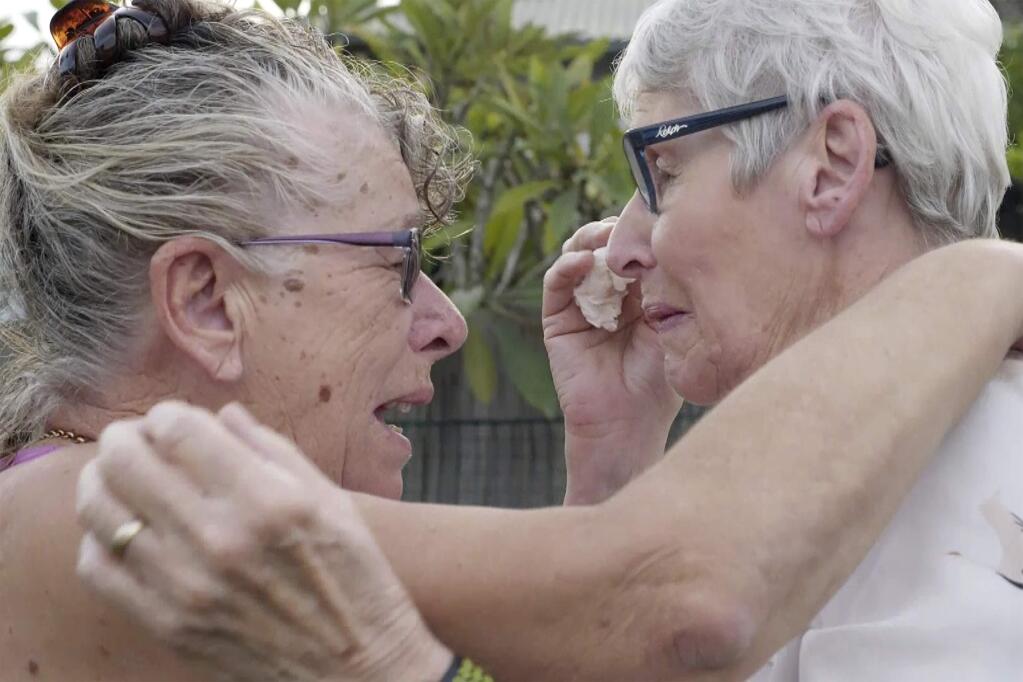 Christine Archer, right, and her sister Gail Baker cry as they are reunited in Bowraville, Australia Wednesday, May 20, 2020. Australia had rejected Archer's request for permission to fly from New Zealand four times before her story attracted media attention. Her only sister Baker was diagnosed with incurable ovarian cancer in late March after both countries stopped international travel. Baker has perhaps weeks to live. Archer was eventually allowed to fly to Sydney and spent only a week in hotel quarantine before testing negative for the coronavirus. (AuBC via AP)