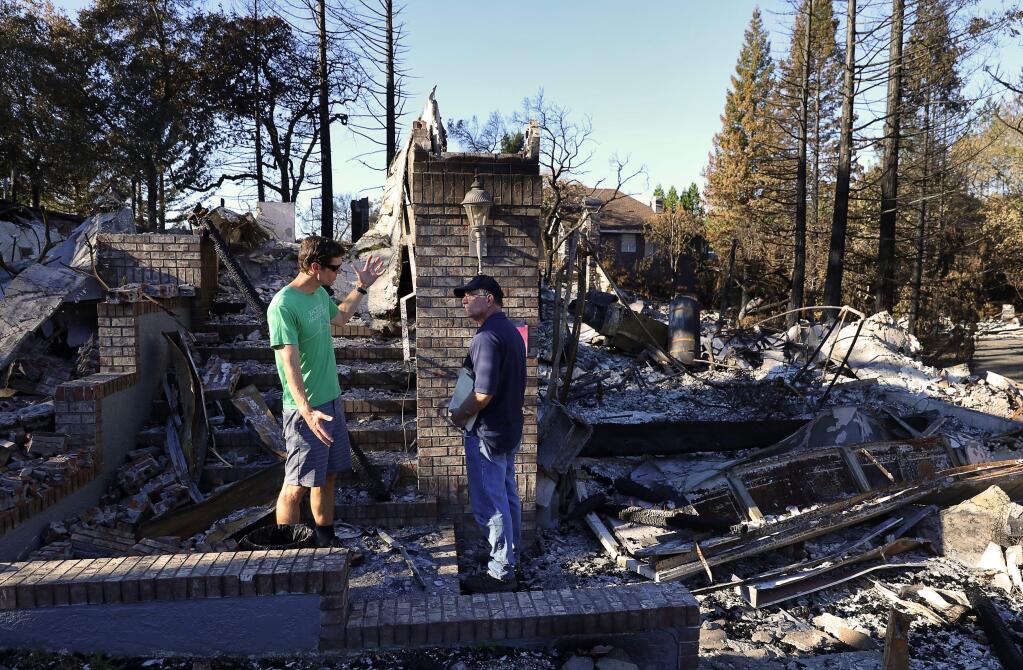 Dr. Robert Nied, left, a sports medicine physician at Kaiser Permanente, meets with Farmers Insurance adjuster Ron Ryan at the site of his burned home on Cannes Place, in the Fountaingrove area of Santa Rosa on Tuesday, October 24, 2017. (Christopher Chung/ The Press Democrat)