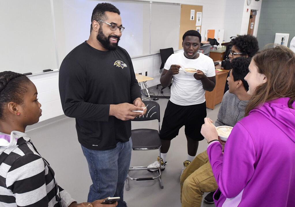 Baltimore Ravens lineman and math scholar John Urschel, second from left, eats ice cream with students after teaching a lesson at Dundalk High School during the launch of Texas Instruments' STEM Behind Cool Careers series on Tuesday, July 18, 2017 in Baltimore. (Steve Ruark/AP Images for Texas Instruments)