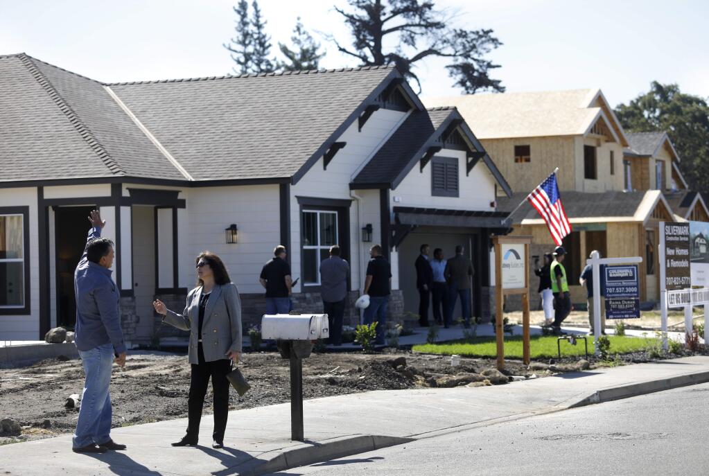 Silvermark Construction Services chief operating officer David Hosking, left, talks with Jacqueline Christensen, a vice president of Exchange Bank, about homes being rebuilt on Willow Green Place in the unincorporated area of Sonoma County. Photo taken near Santa Rosa on Thursday, June 21, 2018. (Beth Schlanker/ The Press Democrat)
