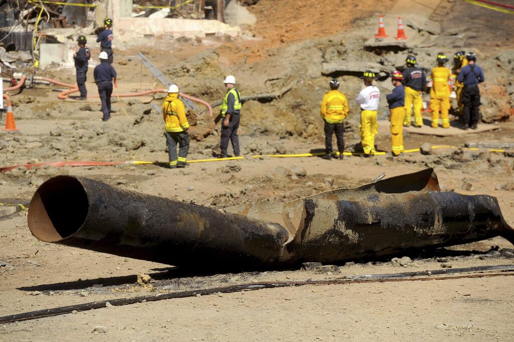 FILE - In this Sept. 11, 2010, file photo, a natural gas line lies broken on a San Bruno, Calif., road after a massive explosion. The California Public Utilities Commission said Friday, Dec. 14, 2018, that an investigation by its staff found Pacific Gas & Electric Co. lacked enough employees to fulfill requests to find and mark natural gas pipelines. A U.S. judge fined the utility $3 million after it was convicted of six felony charges for failing to properly maintain a natural gas pipeline that exploded south of San Francisco in 2010, killing eight people. (AP Photo/Noah Berger, File)