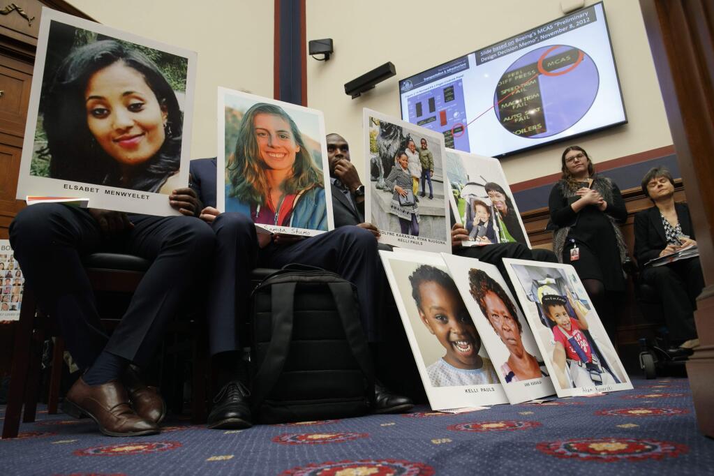 People holding photos of those lost in Ethiopian Airlines Flight 302 and Lion Air Flight 610 listen during a House Transportation and Infrastructure Committee hearing with Boeing executives, Wednesday, Oct. 30, 2019, on Capitol Hill in Washington. (AP Photo/Jacquelyn Martin)