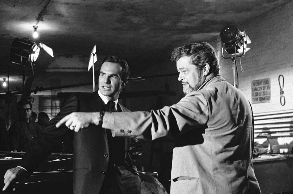 FILE - In this May 27, 1966 file photo, actor Burt Reynolds, left, discusses a scene with director Paul Bogart during location shooting of a new ABC-TV series 'Hawk', in New York. Reynolds, who starred in films including 'Deliverance,' 'Boogie Nights,' and the 'Smokey and the Bandit' films, died at age 82, according to his agent. (AP Photo/Joe Caneva, File)