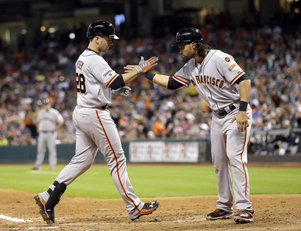 San Francisco Giants' Buster Posey (28) is congratulated by Angel Pagan after both scored on Posey's home run against the Houston Astros during the fifth inning of a baseball game Wednesday, May 13, 2015, in Houston. (AP Photo/David J. Phillip)