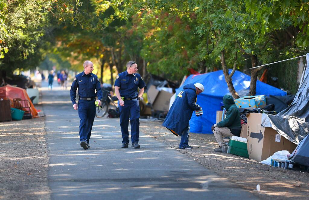 Santa Rosa Fire Department assistant fire marshal Paul Lowenthal, left, and battalion chief Mike McCallum walk through a homeless encampment along the Joe Rodota Trail, west of Stony Point Road, while looking for potential hazards, in Santa Rosa on Monday, October 14, 2019. (Christopher Chung/ The Press Democrat)