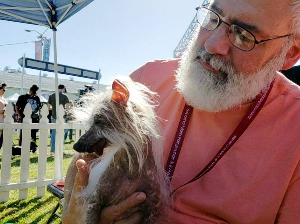 Kelly Wilson of Oregon holds his family dog Moogie before the start of the World's Ugliest Dog Contest at the Sonoma-Marin Fair in Petaluma, California on Friday, June 21, 2019. (Alvin Jornada/The Press Democrat)