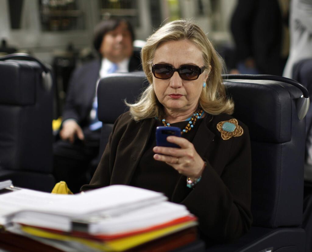 FILE - In this Oct. 18, 2011, file photo, then-Secretary of State Hillary Rodham Clinton checks her BlackBerry from a desk inside a C-17 military plane upon her departure from Malta, in the Mediterranean Sea, bound for Tripoli, Libya. Clinton insists that if she pursues the presidency again, it will be different this time around. But revelations that she sidestepped the government email system as secretary of state suggest she may have a long way to go in making good on that promise. (AP Photo/Kevin Lamarque, Pool, File)