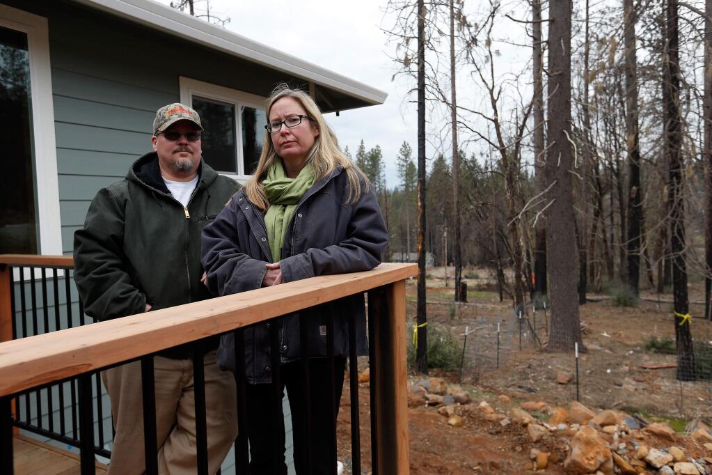 A group of dead trees, at right, remain standing uncomfortably close to Patrick and Cathy McCarthy's rebuilt home in Cobb, California on Tuesday, January 17, 2017. (Alvin Jornada / The Press Democrat)