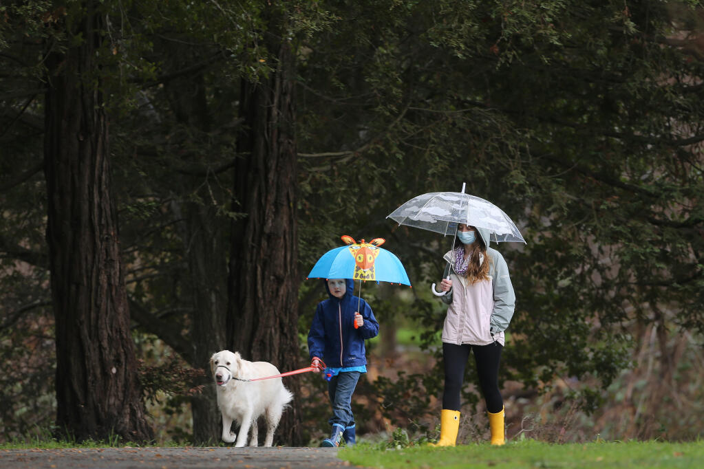 Renee Robinson, her son Ethan, 8, and dog Oliver walk along the Lynch Creek Trail, in Petaluma, California, on Sunday, Jan. 24, 2021. (Beth Schlanker / The Press Democrat)