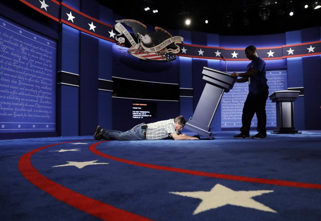 Technicians set up the stage for the presidential debate between Democratic presidential candidate Hillary Clinton and Republican presidential candidate Donald Trump at Hofstra University in Hempstead, N.Y., Sunday, Sept. 25, 2016. (AP Photo/Patrick Semansky)