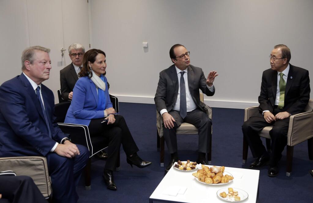 French President Francois Hollande, second right, meets United Nations Secretary General Ban Ki-moon, right, with French Environment Minister Segolene Royal and former U.S vice-president Al Gore, Saturday, Dec.12, 2015 at the COP2, the United Nations Climate Change Conference, in Le Bourget, north of Paris. French Foreign Minister Laurent Fabius says a 'final' draft of a global climate pact would be legally binding. (Philippe Wojazer, Pool, via AP)
