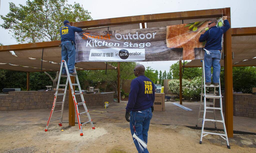 (From left) Mario Newton, Kevin Griffen and Donald Lewis install the banner for the soon-to-be completed kitchen area. The Sunset Outdoor Kitchen Stage at Cornerstone will be ready for the grand opening in 2016. (Robbi Pengelly/Index-Tribune)