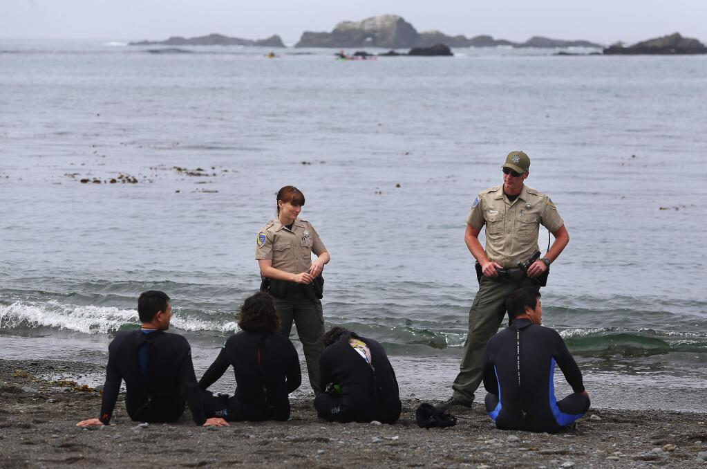 Fish and Wildlife wardens Kathleen Boele, left, and Todd Kinnard detain abalone divers being cited for multiple violations at Van Damme State Park, near Little River, on Friday, May 22, 2015. (Christopher Chung / The Press Democrat) Sonoma Magazine