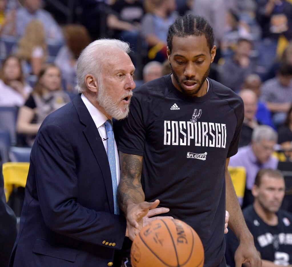 In this April 22, 2017, file photo, San Antonio Spurs head coach Gregg Popovich, left, talks with San Antonio Spurs forward Kawhi Leonard during the second half of Game 4 of their first-round playoff series against the Memphis Grizzlies, in Memphis, Tenn. (AP Photo/Brandon Dill, File)