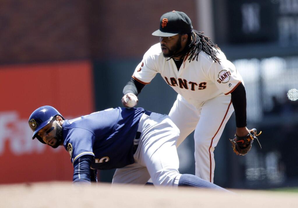 San Francisco Giants starting pitcher Johnny Cueto, right, tags out Milwaukee Brewers' Jonathan Villar in a run down between first and second base during the first inning of a baseball game Wednesday, June 15, 2016, in San Francisco. (AP Photo/Marcio Jose Sanchez)