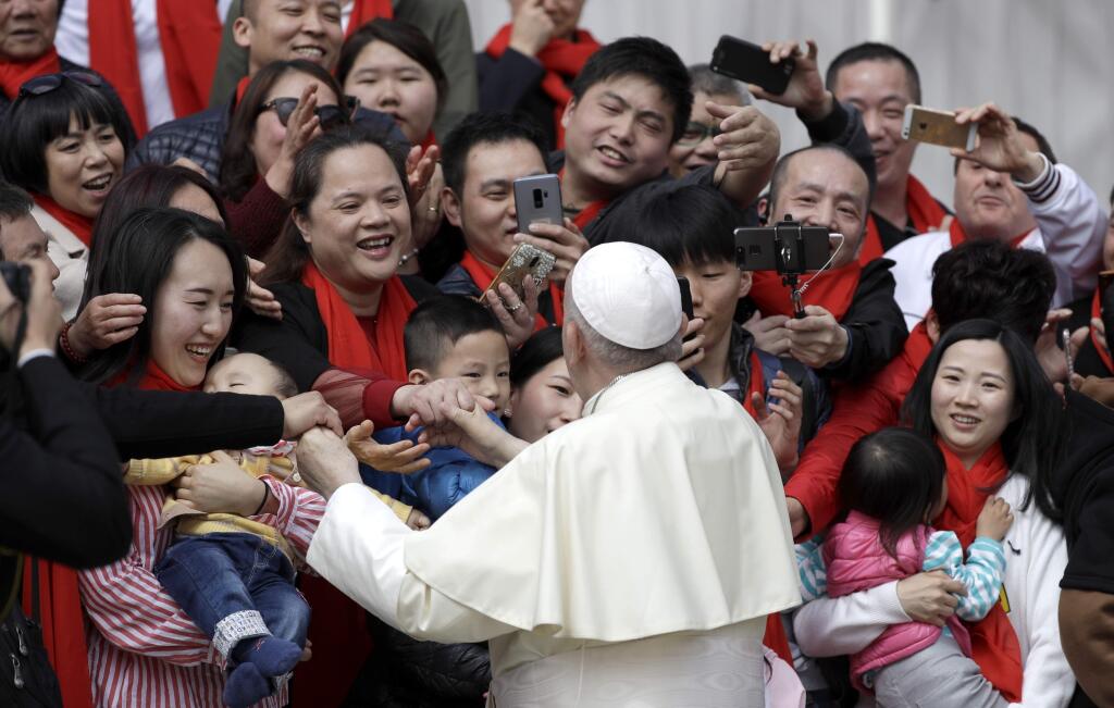 FILE - In this April 18, 2018 file photo, Pope Francis meets a group of faithful from China at the end of his weekly general audience in St. Peter's Square, at the Vatican. On Saturday, Sept. 22, 2018, the Vatican announced it had signed a 'provisional agreement' with China on the appointment of bishops, a breakthrough on an issue that for decades fueled tensions between the Holy See and Beijing and thwarted efforts toward diplomatic relations. (AP Photo/Gregorio Borgia, file)